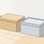 室内の床に並んだ、使い込まれた木の道具箱と、新しいグレーの樹脂の箱