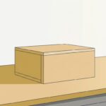 夕方の作業場。明るい木の作業台の上に、明るい木の四角い箱が1つ置かれている