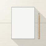 夕方の光が差す木の天板の上に、まっさらな白い紙が1枚と、削られた木軸の鉛筆が1本だけ置かれている。