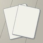 机の上で、同じ大きさの無地のファイル2冊が向きをずらして大きく重なり合っている