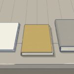 作業台の上に、閉じた無地のファイルが3冊並び、中央の1冊だけが手前にずらして引き出されている。