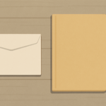 日雇いの日当を入れる封筒と、閉じたファイルが机に置かれている